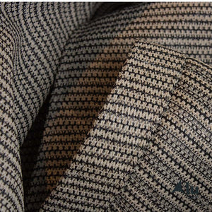 Detailfoto van het materiaal van een zand/zwart kleurig schaduwdoek